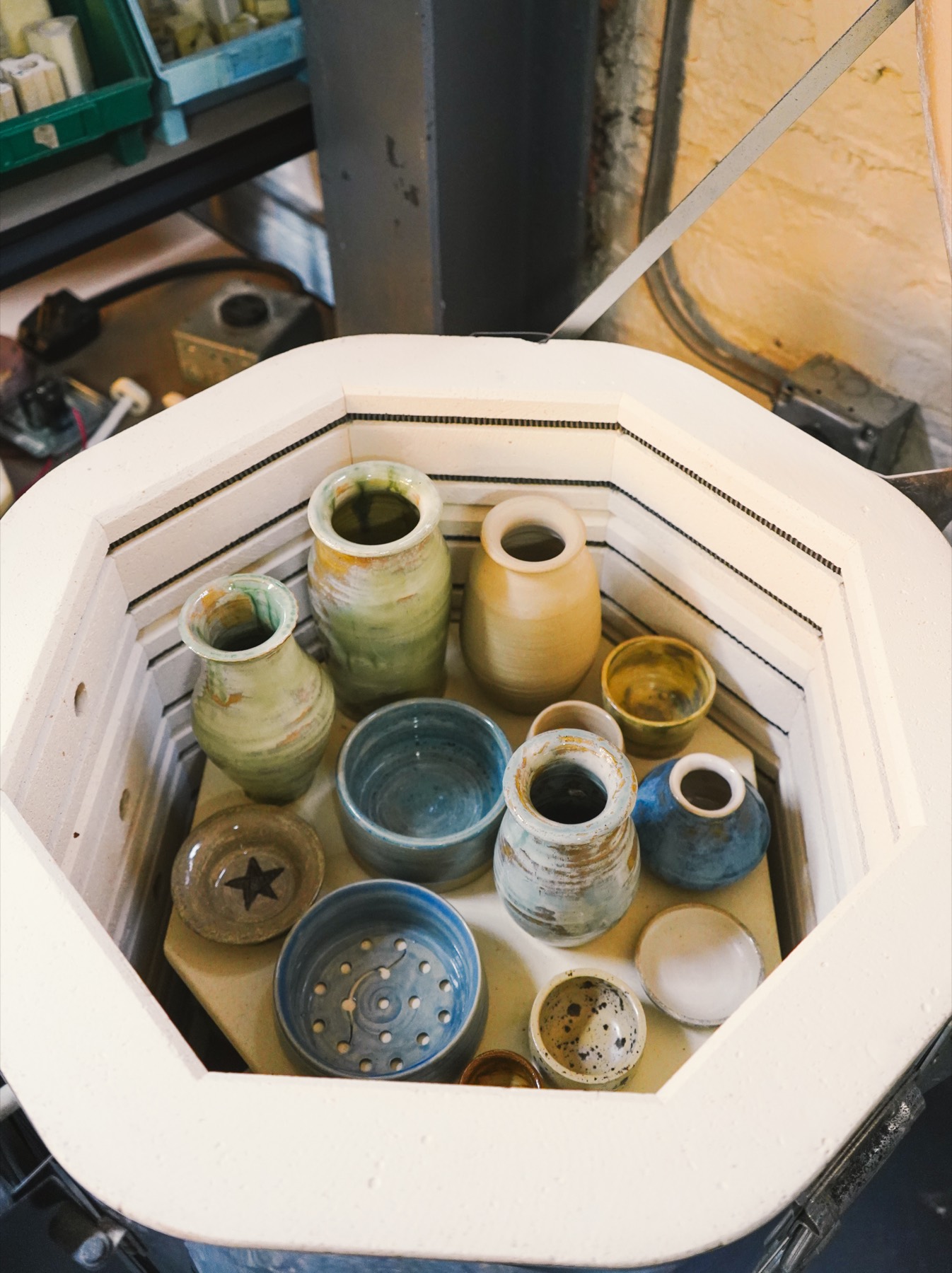 Glazed work still stacked on the kiln shelf, seen from above