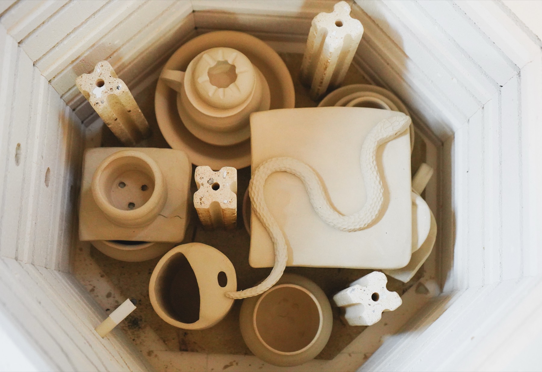 Bisque-fired handbuilt pieces resting in the open kiln