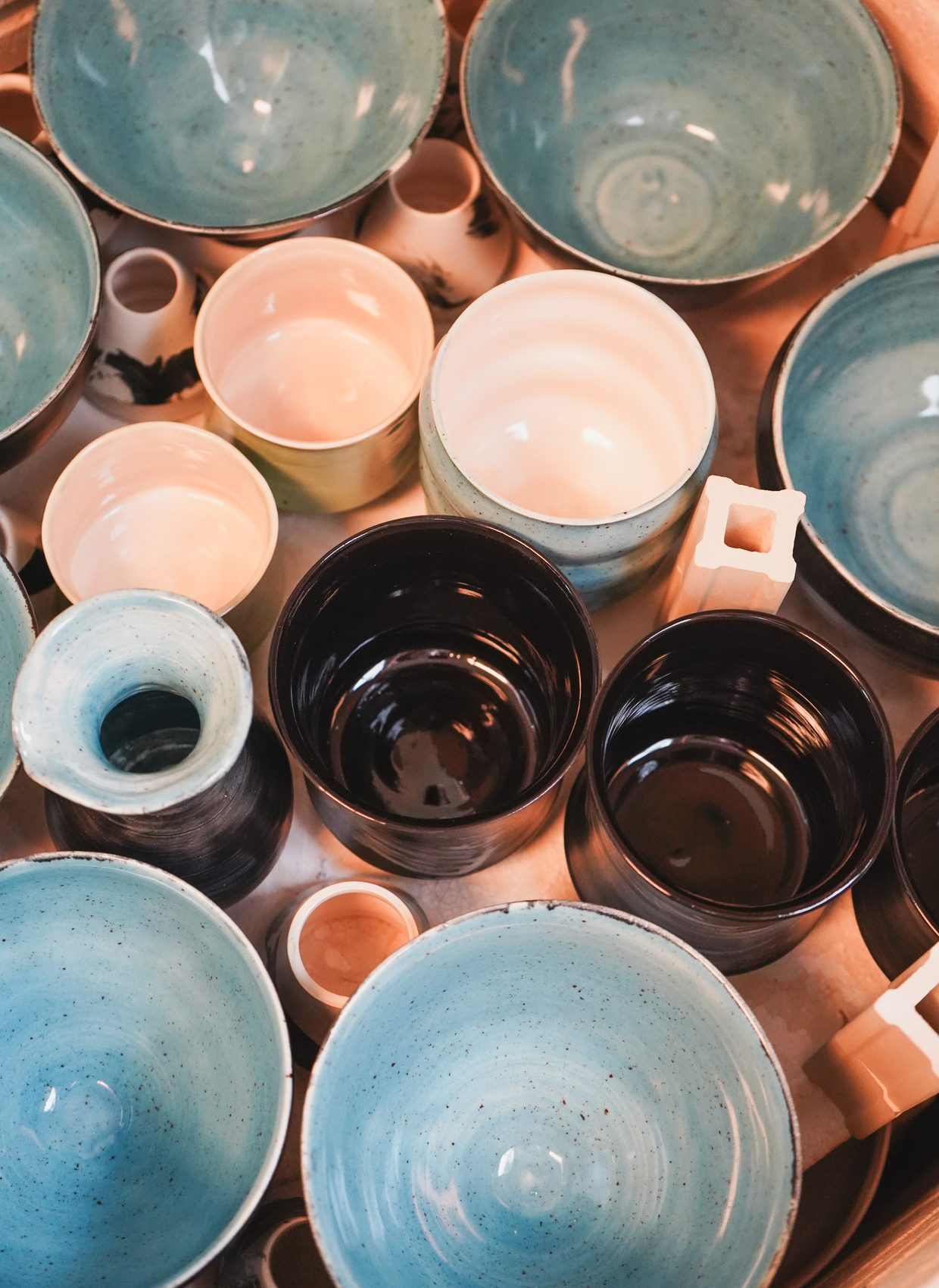 Turquoise and black glazed bowls nested together fresh from the kiln
