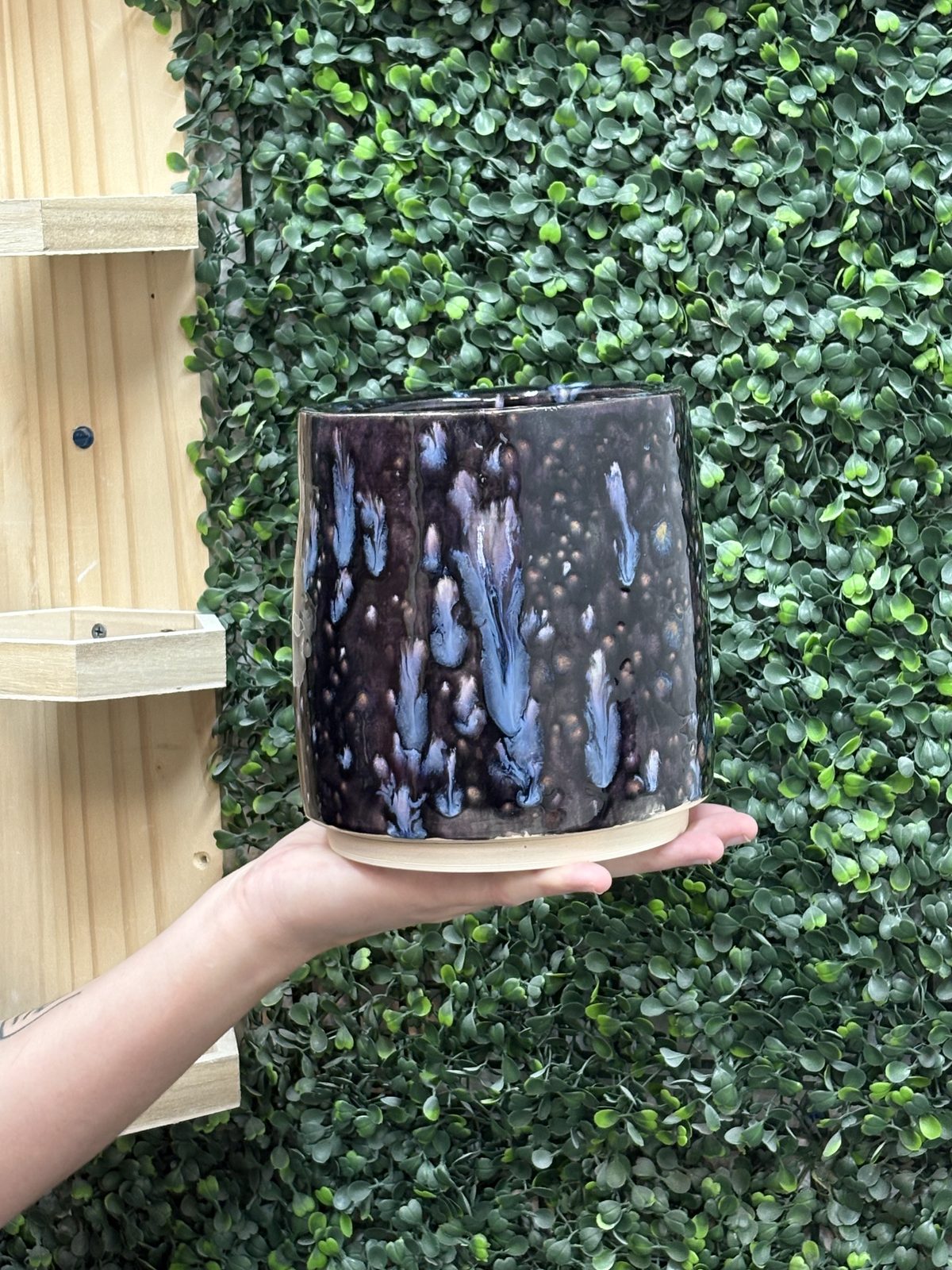 A member holding a mug with a black and white marbled glaze