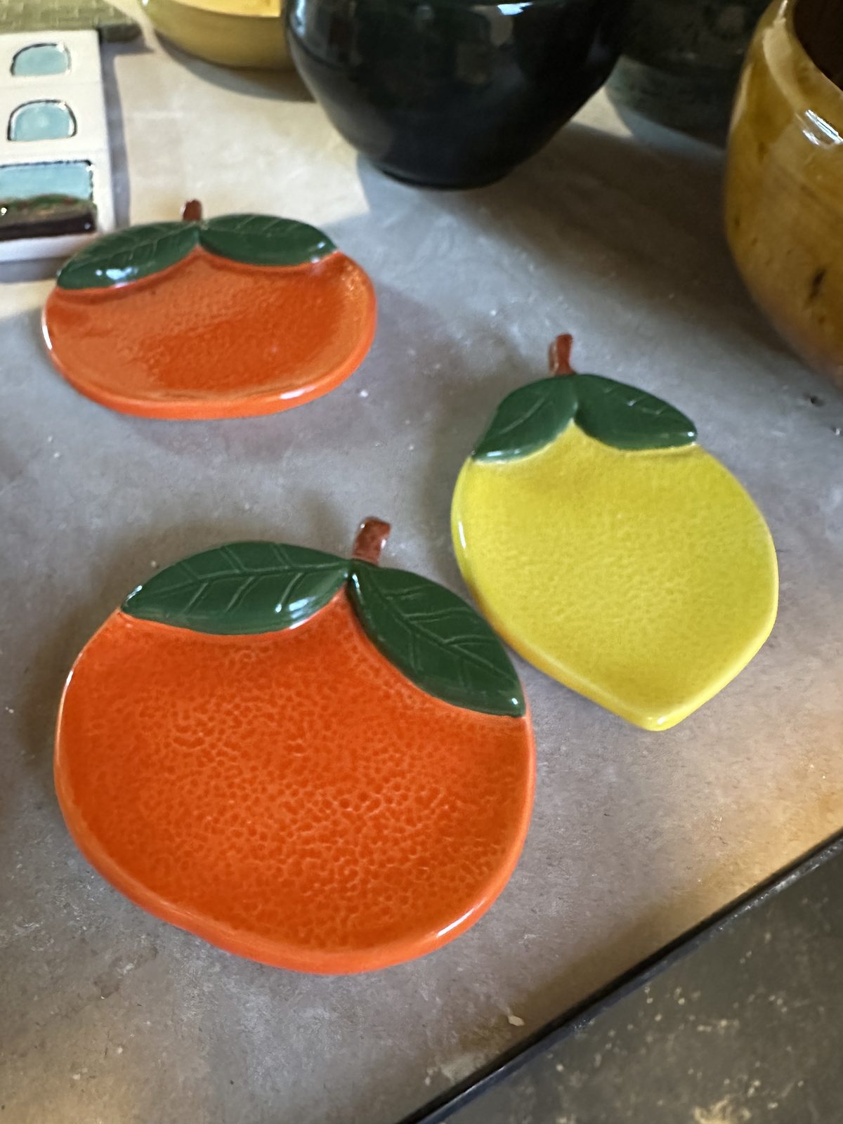 Orange- and lemon-shaped ceramic dishes with painted leaves