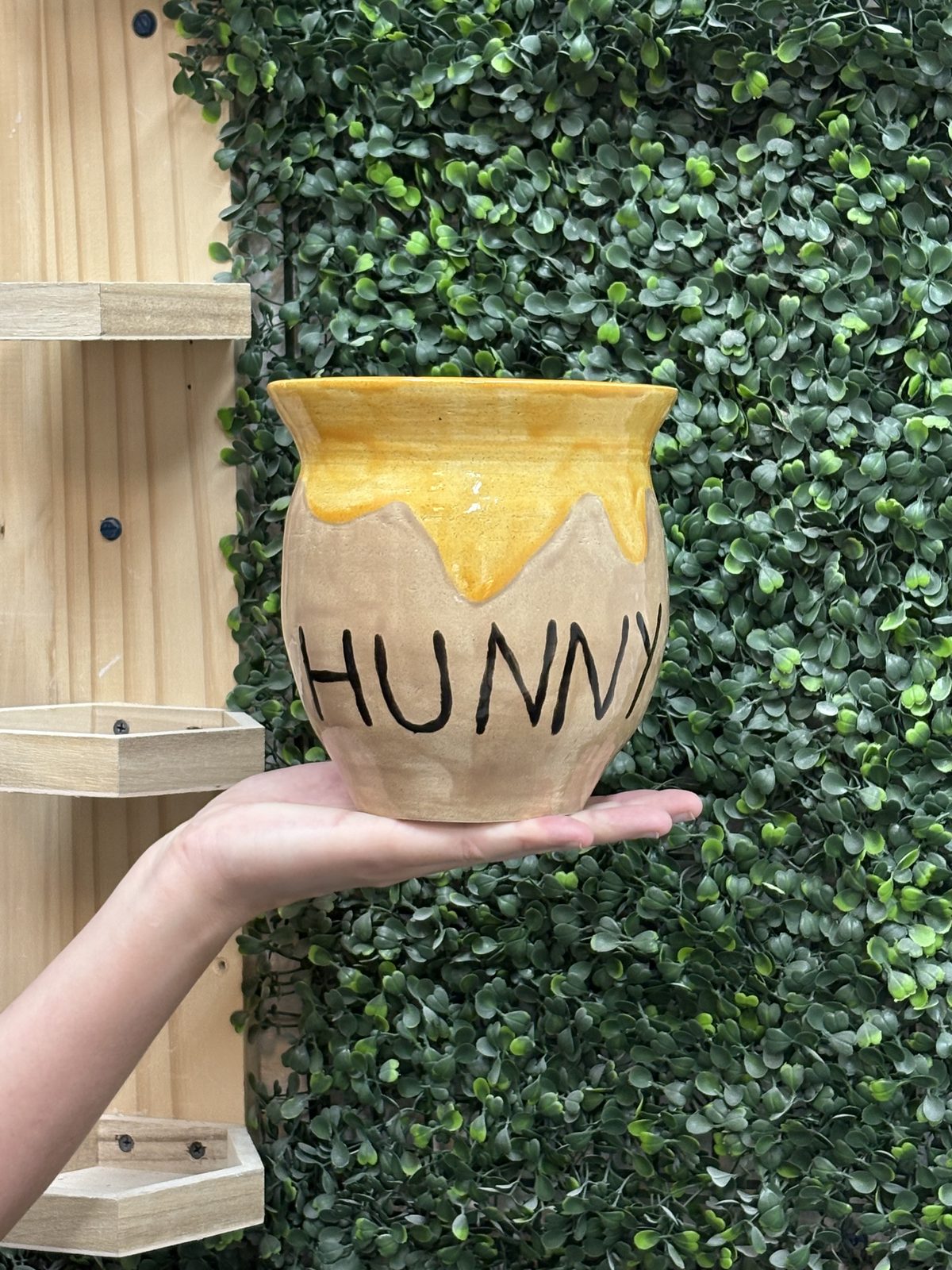 A honey-pot shaped mug reading 'HUNNY' in a warm honey glaze
