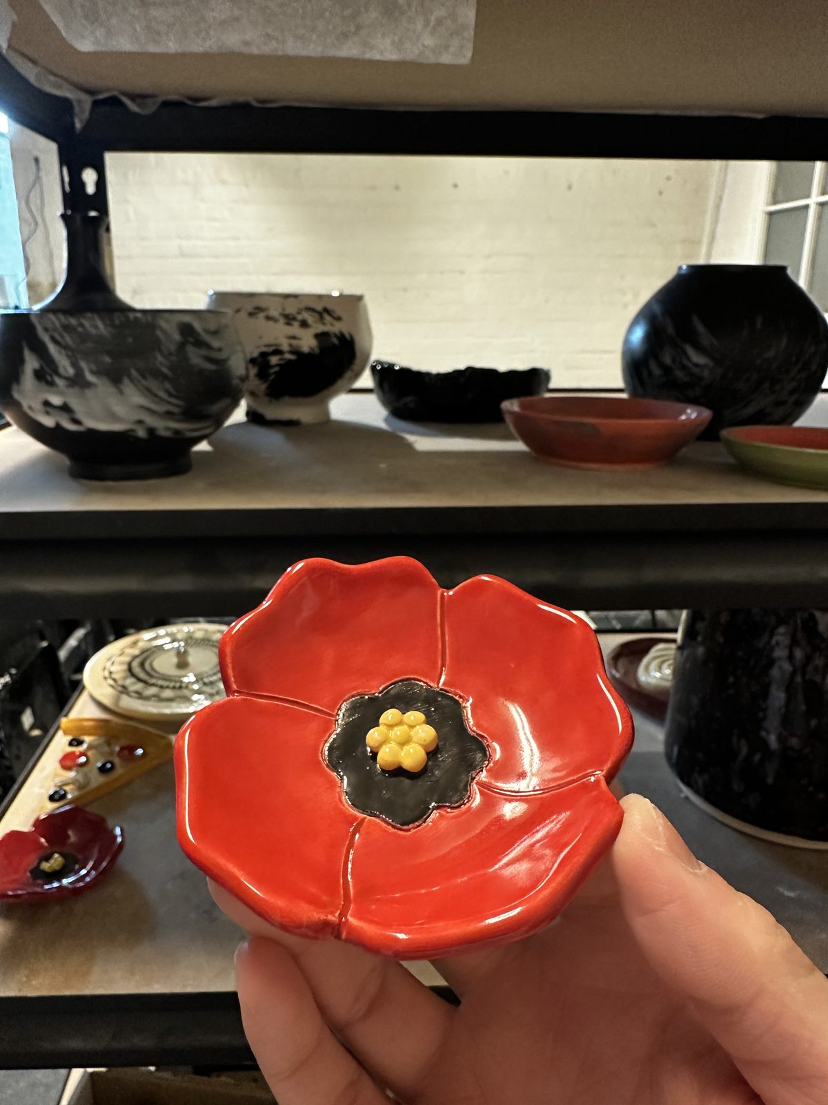 A member holding a red flower-shaped dish