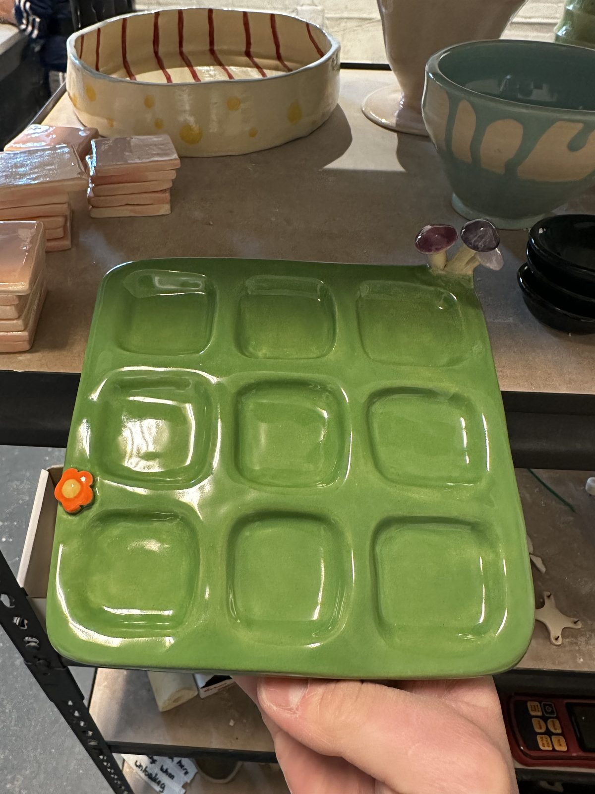 A green ceramic tray divided into square compartments